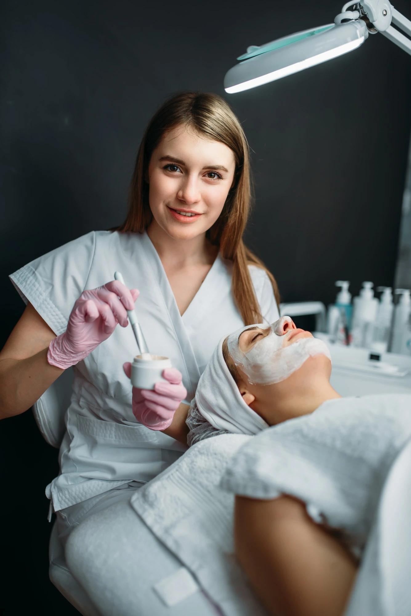 Female doctor holds cream and brush in hands